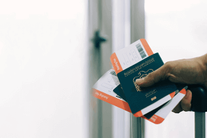 A person holding a passport and boarding pass