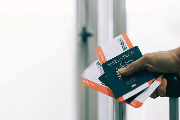 A person holding a passport and boarding pass